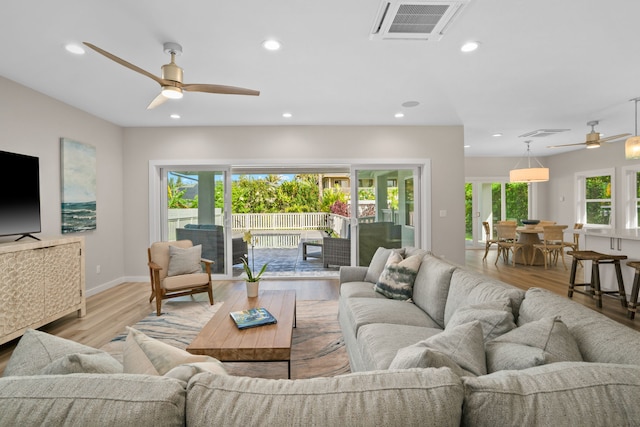 living room with light wood-type flooring and ceiling fan