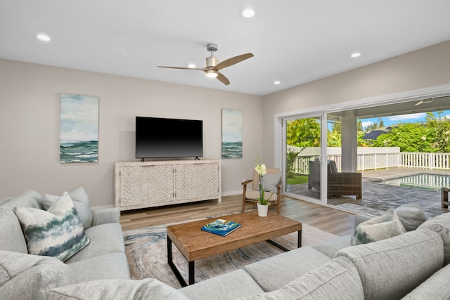 living room with ceiling fan and light hardwood / wood-style flooring