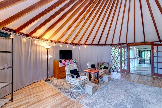 living room featuring vaulted ceiling with beams and hardwood / wood-style flooring