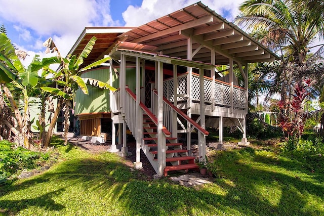 back of house featuring a deck and a lawn