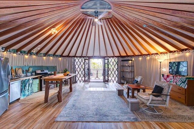 interior space with light wood-type flooring, sink, and vaulted ceiling