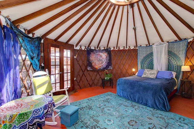 carpeted bedroom with french doors and vaulted ceiling