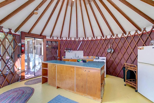 interior space featuring sink and lofted ceiling with beams