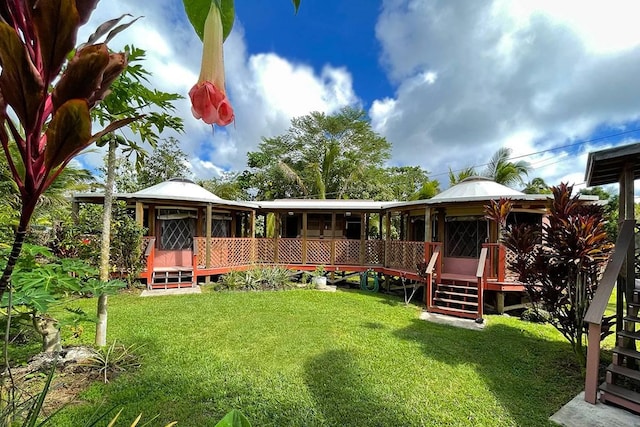 rear view of house with a gazebo and a lawn