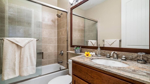 full bathroom featuring shower / bath combination with glass door, vanity, and toilet