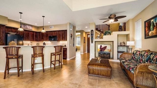 interior space featuring kitchen peninsula, tasteful backsplash, ceiling fan, black appliances, and decorative light fixtures