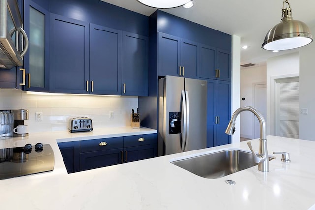 kitchen with backsplash, pendant lighting, stainless steel appliances, and blue cabinets