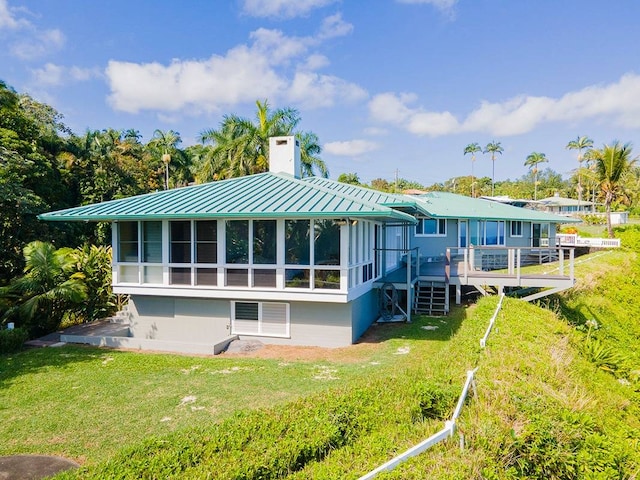 rear view of property featuring a wooden deck and a yard