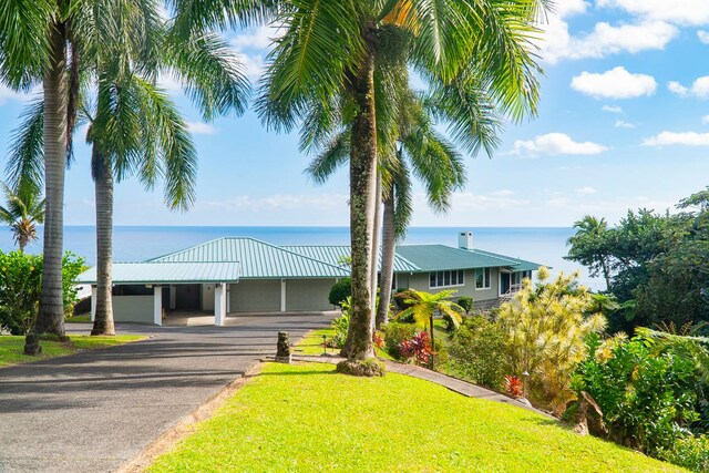 view of front of home with a front lawn and a water view