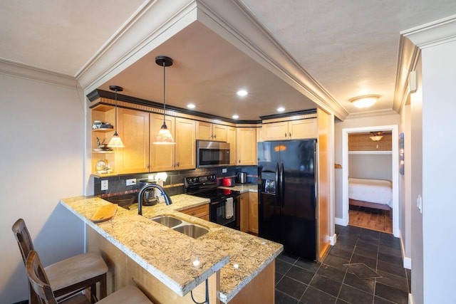 kitchen featuring hanging light fixtures, black appliances, a kitchen bar, sink, and light stone counters