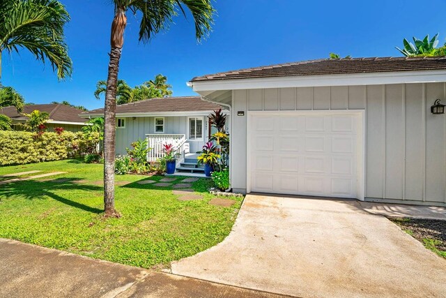 ranch-style house featuring a front yard and a garage