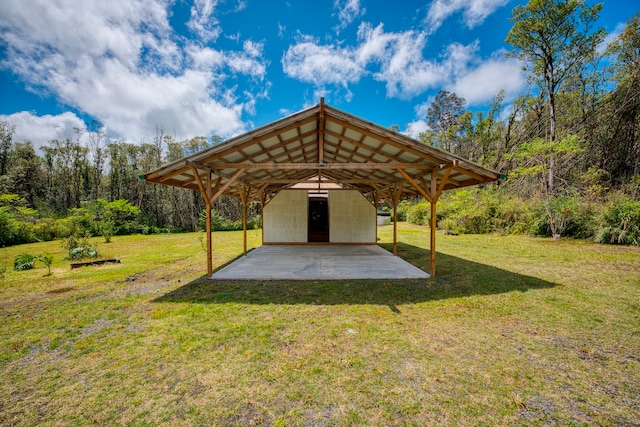 view of property's community with a patio, an outdoor structure, and a lawn