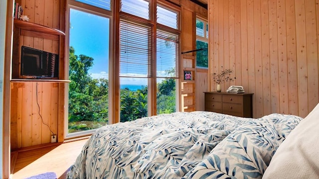 bedroom with wood-type flooring and wooden walls