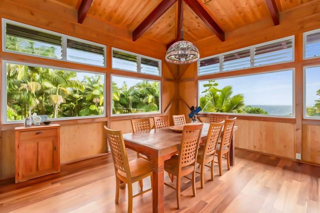 dining area featuring beamed ceiling, light hardwood / wood-style flooring, plenty of natural light, and wooden ceiling