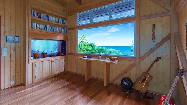 interior space with hardwood / wood-style floors and wooden walls