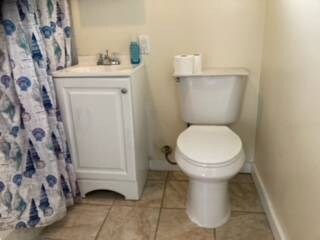 bathroom featuring tile flooring, toilet, and vanity