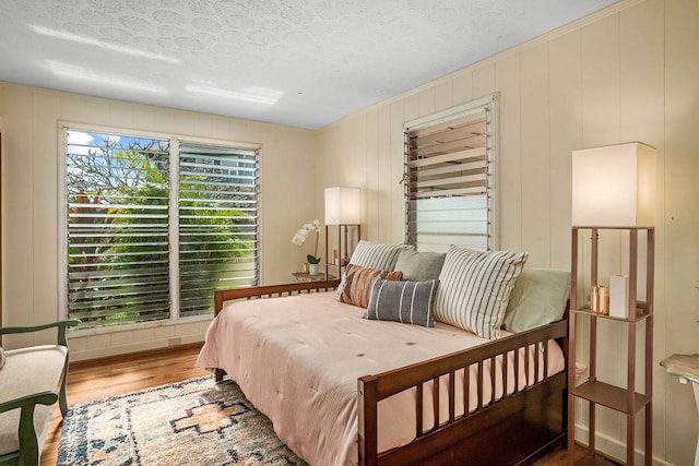 bedroom with hardwood / wood-style floors and a textured ceiling