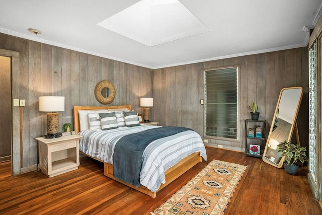 bedroom with ornamental molding, a skylight, wood walls, and dark wood-type flooring