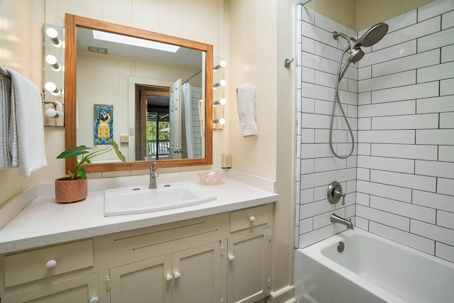 bathroom featuring tiled shower / bath and vanity