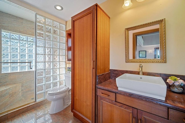 bathroom featuring oversized vanity, toilet, and plenty of natural light