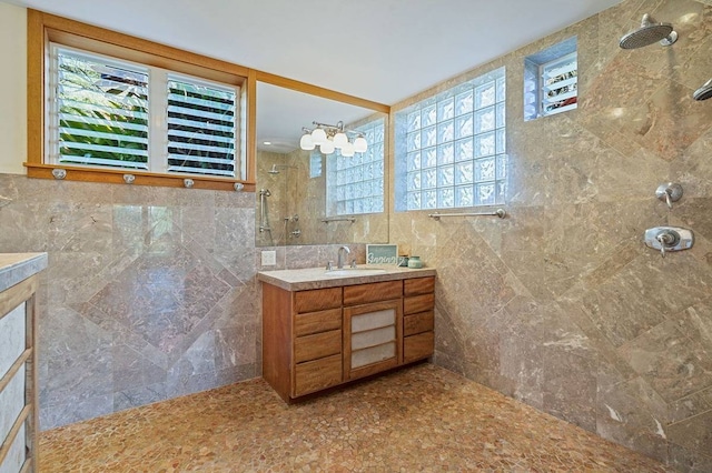 bathroom featuring vanity, tiled shower, and tile walls