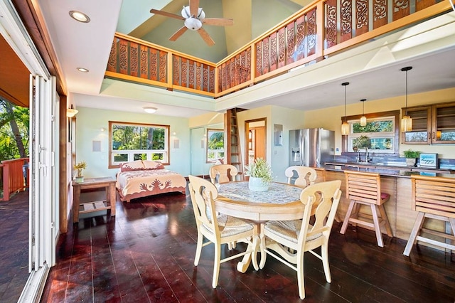 dining room featuring sink, ceiling fan, and a high ceiling