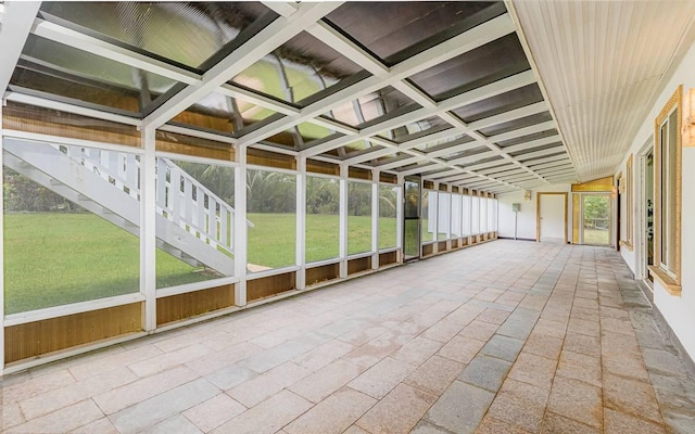 unfurnished sunroom featuring coffered ceiling and beam ceiling