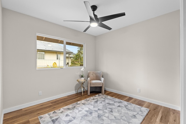 sitting room featuring wood-type flooring and ceiling fan