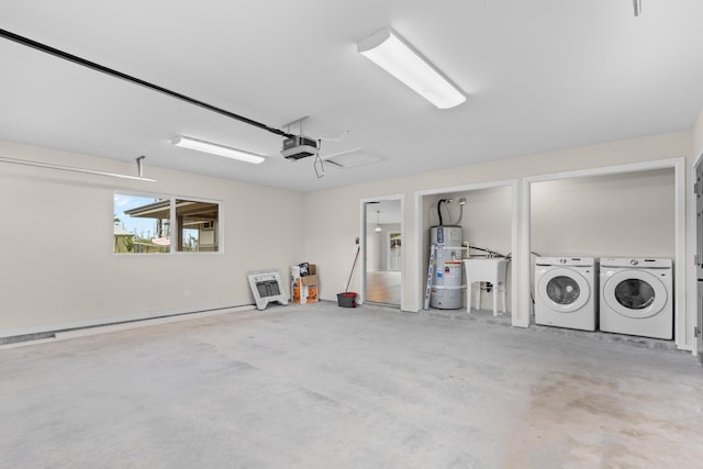 garage with separate washer and dryer, sink, a garage door opener, and water heater