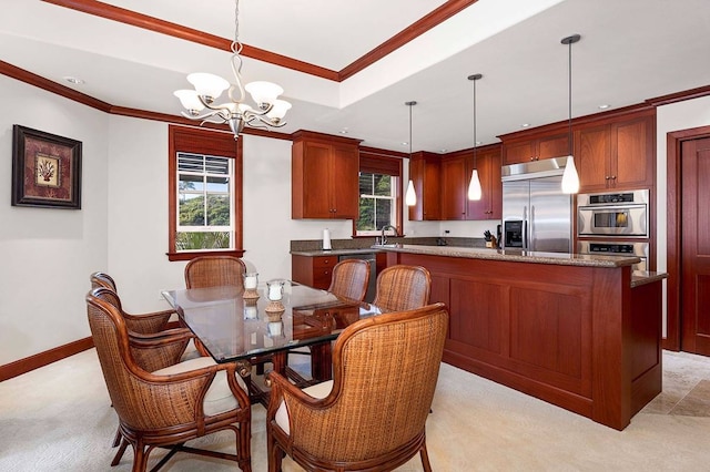 kitchen with pendant lighting, stainless steel appliances, a notable chandelier, ornamental molding, and a raised ceiling