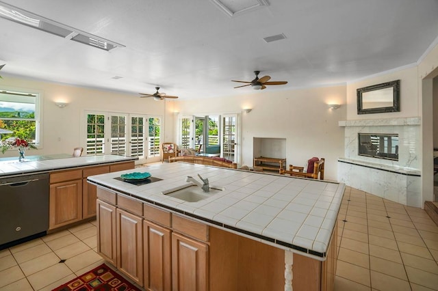 kitchen featuring ceiling fan, stainless steel dishwasher, sink, and tile counters