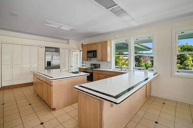 kitchen with light tile floors, a center island with sink, stainless steel fridge, and electric range