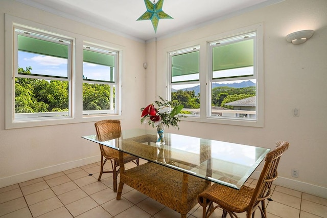 dining area featuring light tile floors, crown molding, and a healthy amount of sunlight