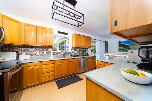 kitchen featuring electric stove, dishwasher, light wood-type flooring, decorative light fixtures, and sink