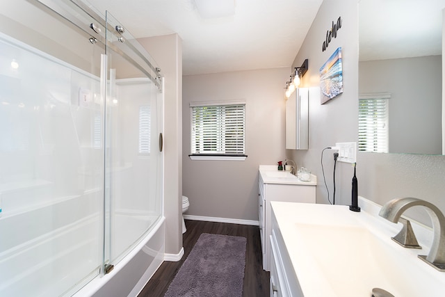 full bathroom featuring hardwood / wood-style floors, plenty of natural light, vanity, and toilet