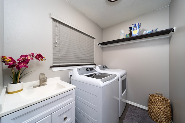 laundry room with cabinets, a textured ceiling, and washer and dryer