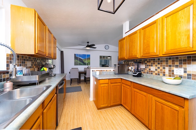 kitchen with dishwasher, light hardwood / wood-style flooring, lofted ceiling, and decorative backsplash