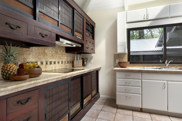 kitchen featuring dark brown cabinetry, white cabinetry, sink, and light tile patterned floors