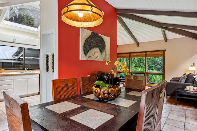 tiled dining area with beamed ceiling and high vaulted ceiling