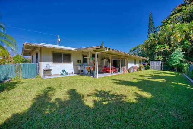 back of property with a patio, a shed, and a lawn