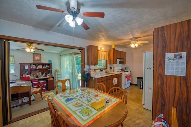 tiled dining room featuring ceiling fan and sink