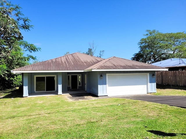 ranch-style home featuring covered porch, a front lawn, and a garage