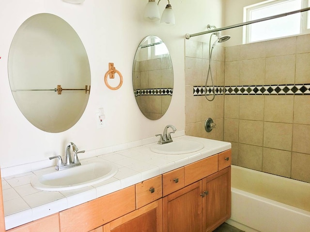 bathroom featuring tiled shower / bath combo and dual vanity