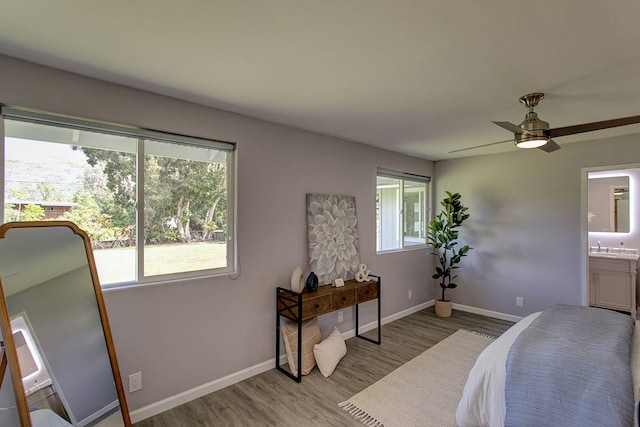 bedroom with ceiling fan, ensuite bath, and hardwood / wood-style flooring