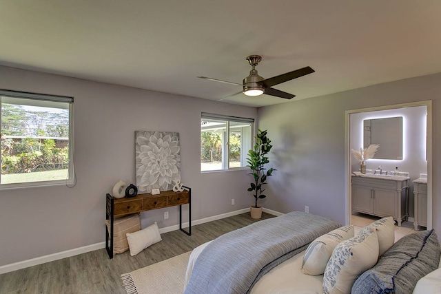 bedroom featuring light hardwood / wood-style floors, connected bathroom, ceiling fan, and sink