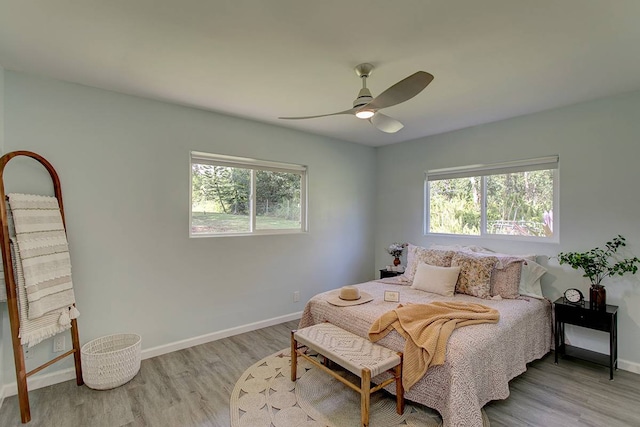 bedroom featuring multiple windows, light wood-type flooring, and ceiling fan