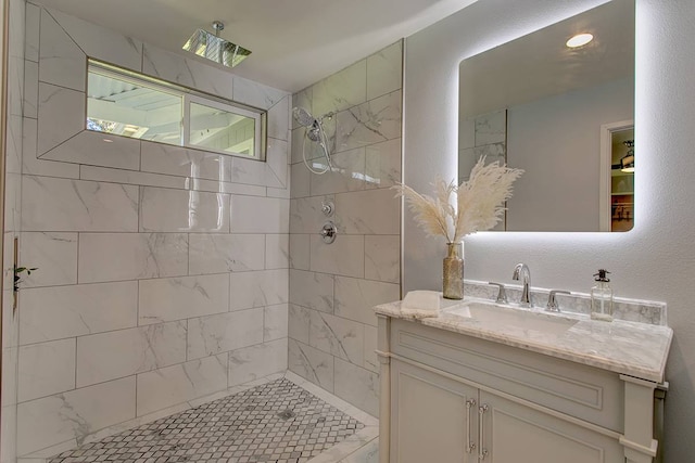 bathroom with vanity with extensive cabinet space and a tile shower