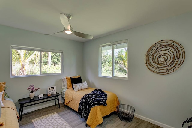 bedroom featuring multiple windows, ceiling fan, and hardwood / wood-style flooring