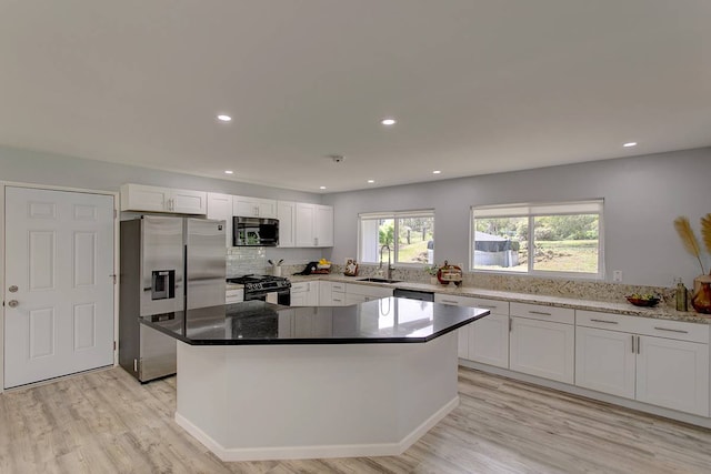 kitchen with white cabinets, stainless steel appliances, and a center island