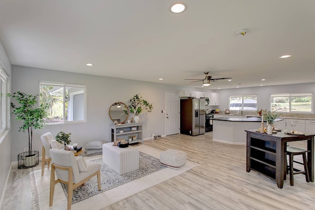 living room with light hardwood / wood-style floors and ceiling fan